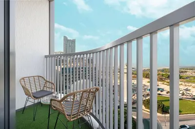 a balcony with two chairs and a view of a city at Luxurious Crest Tower Suites By Hostiva- Burj View in Dubai