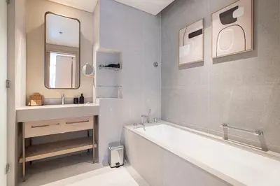 a white bathroom with a tub and a sink at 2BR Vida Dubai Mall Tower 2 Direct Mall Access in Dubai