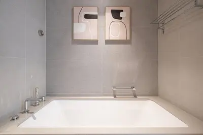 a bath tub in a bathroom with two pictures on the wall at 2BR Vida Dubai Mall Tower 2 Direct Mall Access in Dubai