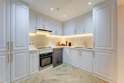 a white kitchen with white cabinets and a sink at 2 Bedroom Apartment, JBR Beach with Dubai Eye View in Dubai