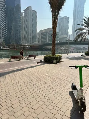a scooter parked on a sidewalk in a city at Fantastic 1 bed apt near Marina & Jumeira Beach in Dubai