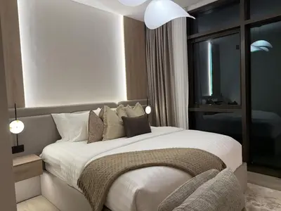 a bedroom with a large bed with white sheets and pillows at Palace Residences, Lux 1BR Apartment, Lagoon View in Dubai