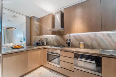 a kitchen with wooden cabinets and a stove top oven at FIVE Palm-Private Pool and Garden-Luxury Suite in Dubai