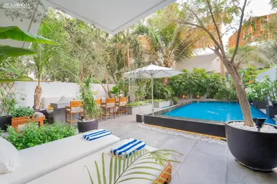 an outdoor patio with a pool and a table and chairs at FIVE Palm-Private Pool and Garden-Luxury Suite in Dubai