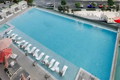 an overhead view of a large swimming pool with lounge chairs at Minutes Walk To Dubai Mall Studio With All Comfort in Dubai