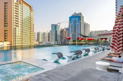 a large swimming pool with chairs and a city skyline at Minutes Walk To Dubai Mall Studio With All Comfort in Dubai