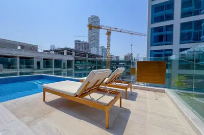 two lounge chairs sitting next to a pool on a building at Pearl House I JVC- 5 Star Facilities- Magnificent Apartment in Dubai