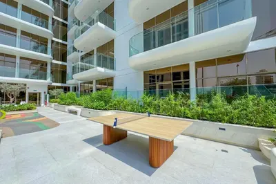 a wooden bench in front of a building at Pearl House I JVC- 5 Star Facilities- Magnificent Apartment in Dubai