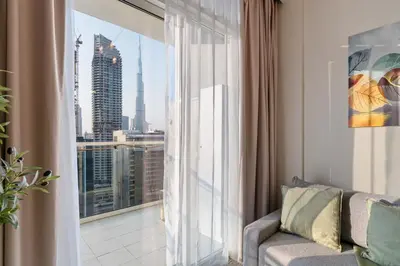 a living room with a couch and a large window at Burj Khalifa&City View 1BR, Near Dubai Water Canal, Vera Tower, Business Bay by Morada Holidays in Dubai