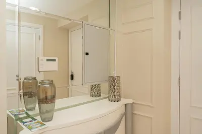a white bathroom with a mirror and vases on a shelf at TRIDENT GRAND JBR I BEACHFRONT 2-Bedroom Apartment I Beautiful Palm and Ocean Views I Amazing Balcony Space in Dubai