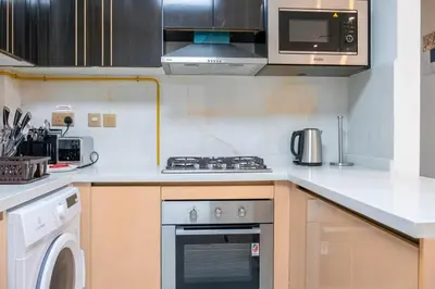 a kitchen with a stove and a microwave at Gemz by Danube with Private Pool - Onelink in Dubai