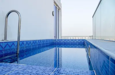 a swimming pool in a building with blue tiles at Gemz by Danube with Private Pool - Onelink in Dubai