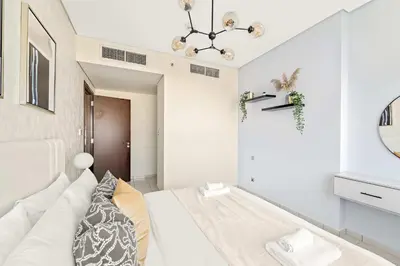 a white room with a bed and a mirror at Silkhaus Deluxe 1BR Stay in Sky gardens in DIFC in Dubai