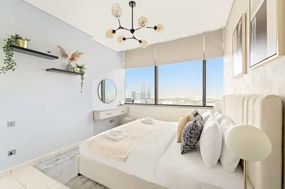a white bedroom with a large bed with windows at Silkhaus Deluxe 1BR Stay in Sky gardens in DIFC in Dubai