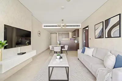 a living room with a white couch and a table at Silkhaus Deluxe 1BR Stay in Sky gardens in DIFC in Dubai