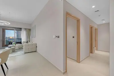 a white living room with a staircase leading to a living room at Full Burj Khalifa 3BR in Act Towers in Dubai