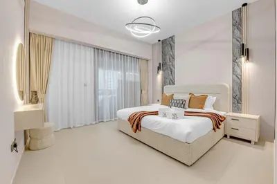 a white bedroom with a large bed and a bathroom at Full Burj Khalifa 3BR in Act Towers in Dubai