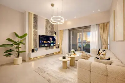 a living room with a couch and a tv at Full Burj Khalifa 3BR in Act Towers in Dubai
