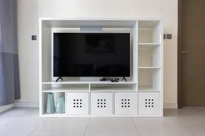 a white entertainment center with a flat screen tv at Bright & Modern 1BR La Rivera Apartments, JVC in Dubai