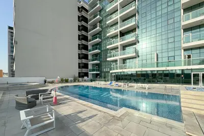 a swimming pool in the middle of a building at Bright & Modern 1BR La Rivera Apartments, JVC in Dubai