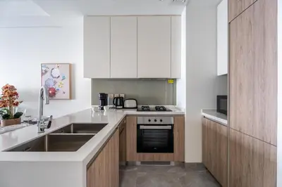 a kitchen with white cabinets and a sink at GuestReady - 2BR l Stunning Canal View in Dubai
