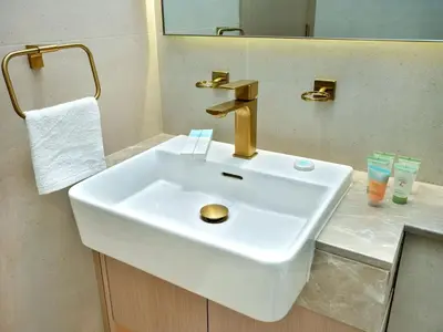 a white sink in a bathroom with a mirror at Bright Apartment in JVC with Pool in Dubai