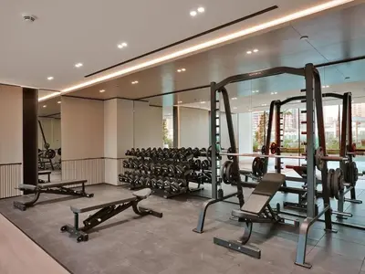 a gym with a lot of tread machines in it at Bright Apartment in JVC with Pool in Dubai