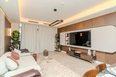 a living room with a white couch and a large tv at Paramount Midtown Luxury 2BR Sleeps 7 Near Business Bay Metro and Dubai Mall in Dubai