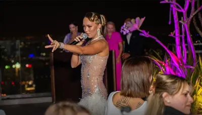 a woman in a silver sequined dress holding a microphone at Paramount Midtown Luxury 2BR Sleeps 7 Near Business Bay Metro and Dubai Mall in Dubai