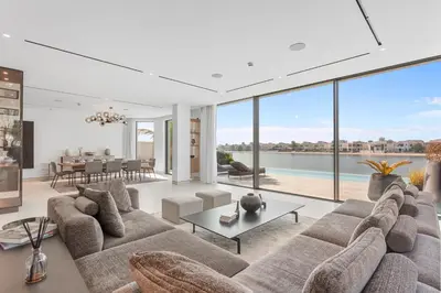 a living room with a large couch and large windows at Premium 4 BR Villa in Palm Jumeirah with Private Pool in Dubai