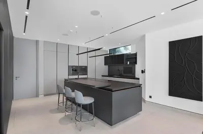 a kitchen with a black counter and stools at Premium 4 BR Villa in Palm Jumeirah with Private Pool in Dubai