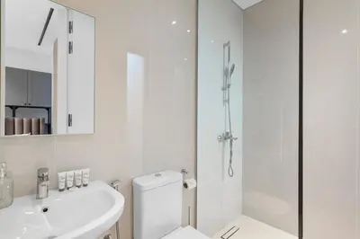 a white bathroom with a toilet and a sink at Premium 4 BR Villa in Palm Jumeirah with Private Pool in Dubai