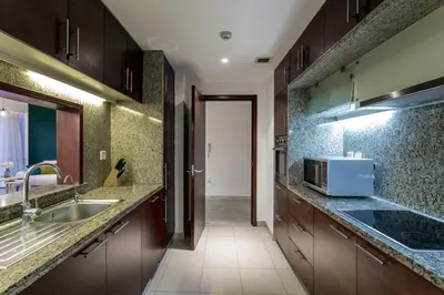 a kitchen with a sink and a microwave at La Dolce Vita in Dubai