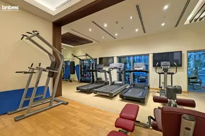 a gym with treadmills and elliptical machines at bnbmehomes - Stand Point Tower A in Dubai