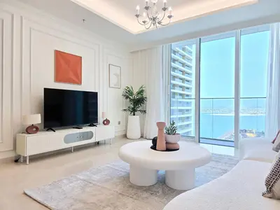 a white living room with a tv and a couch at Luxury Sea View Palace Beach Residence by Emaar in Dubai