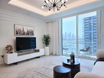 a living room with a tv and a large window at Luxury Sea View Palace Beach Residence by Emaar in Dubai