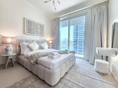 a bedroom with a large bed and a large window at Luxury Sea View Palace Beach Residence by Emaar in Dubai