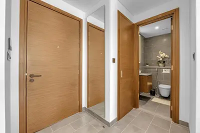 a bathroom with a wooden door and a toilet at Waves - Modern & Cozy 1BR Apt Close to Down Town Dubai in Dubai
