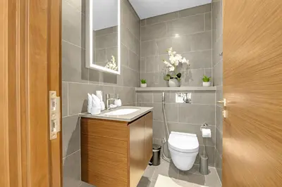 a bathroom with a toilet and a sink and a mirror at Waves - Modern & Cozy 1BR Apt Close to Down Town Dubai in Dubai