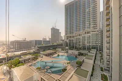 an aerial view of a building with a swimming pool at Waves - Modern & Cozy 1BR Apt Close to Down Town Dubai in Dubai