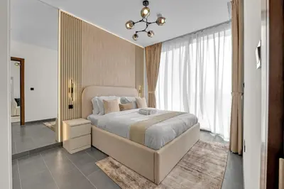a bedroom with a bed and a large window at Waves - Modern & Cozy 1BR Apt Close to Down Town Dubai in Dubai