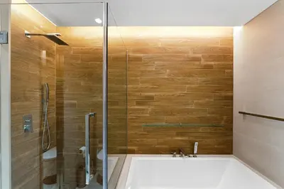 a bathroom with a tub and a glass shower at Bluewaters Residences 1BR Prime Sea and Ain View in Dubai