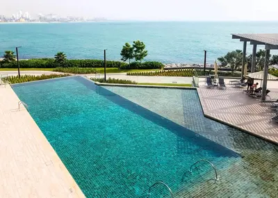 a large swimming pool with a view of the water at Bluewaters Residences 1BR Prime Sea and Ain View in Dubai