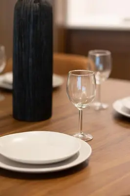 a table with a plate and two glasses on it at Chic 1BR Sea View, Palace Beach Residence in Dubai