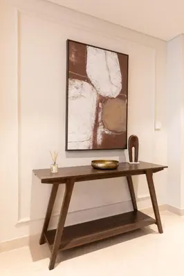 a wooden console table in a room with a painting at Chic 1BR Sea View, Palace Beach Residence in Dubai