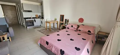 a bedroom with a pink bed and a kitchen at Peace Home in Dubai