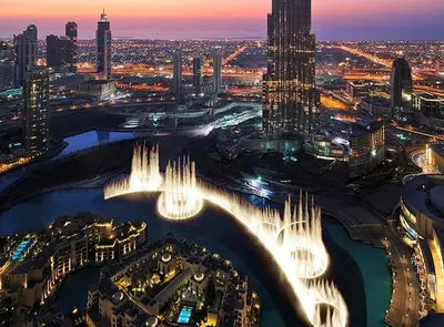 an aerial view of a city at night at Ultra-luxury 2BHK apartment Stunning Burj Khalifa & Fountain view in Dubai