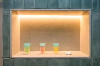 three glasses of beer sitting on a shelf at Upgraded Serene 1BR Retreat in The Greens in Dubai