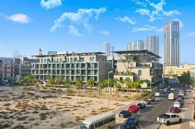 a city street with cars parked in front of a building at Dubai JVC - Oxford Residence 2 - Parking&Balcony in Dubai