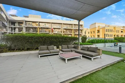 a patio with couches and a table in front of a building at Dubai JVC - Oxford Residence 2 - Parking&Balcony in Dubai